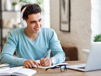 Student taking notes during an online German lesson