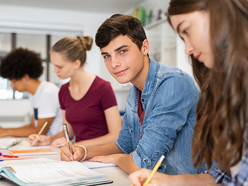 Professeur d'allemand aidant une élève en classe pendant un examen d'allemand.