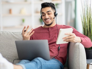 Étudiant suivant un cours d'allemand en ligne depuis son domicile.