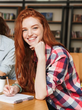 Étudiant préparant un examen d'allemand à la bibliothèque.