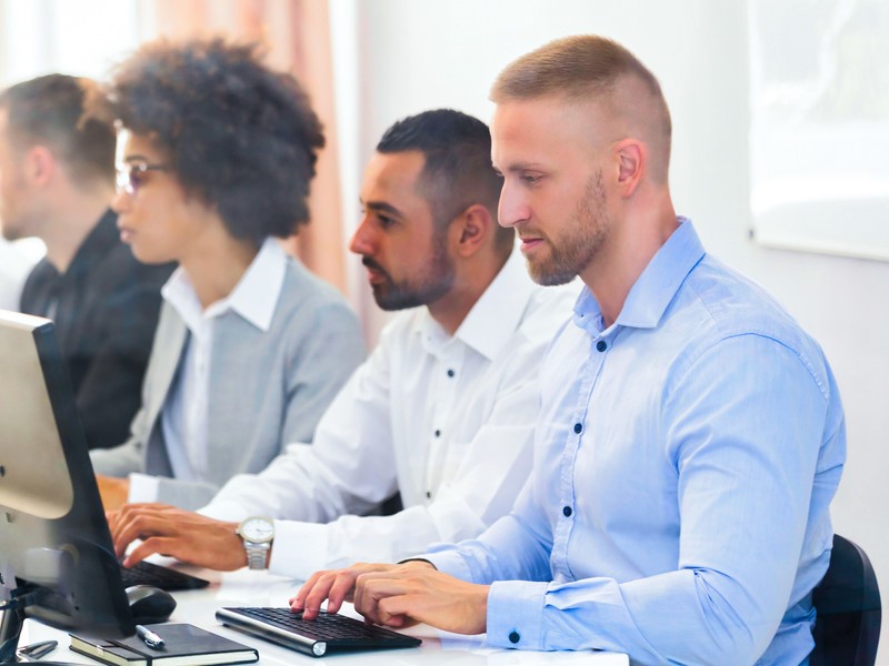 Business executives taking a German online exam with a computer