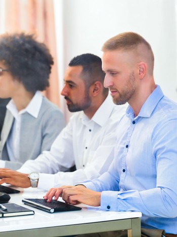 Business executives taking a German online exam with a computer